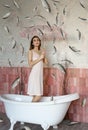 Beautiful young girl standing in the bathroom under the fish rain Royalty Free Stock Photo