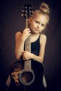 Beautiful young girl standing and holding a guitar