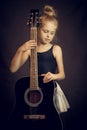 Beautiful young girl standing and holding a guitar