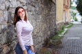 Beautiful young girl standing near the stone wall. Portrait pretty young fashion girl near a stone wall. Beautiful blonde woman Royalty Free Stock Photo