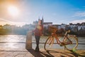 A beautiful young girl stands on the embankment near a city bicycle with a basket of red in Switzerland, the city of Basel. Sunny Royalty Free Stock Photo