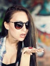 Beautiful young girl in sunglasses is going to swallow pills. Royalty Free Stock Photo