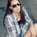 Beautiful young girl in sunglasses is going to swallow pills. Royalty Free Stock Photo