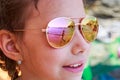 Beautiful young girl in sunglasses with sea reflection. Royalty Free Stock Photo