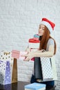 Beautiful young girl in T-shirt and a hat holding presents, boxes