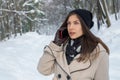 Beautiful young girl talking on the phone outside in a snowy for Royalty Free Stock Photo