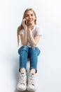 Beautiful young girl talking on the phone, in the Studio, isolated background, cheerful and positive Royalty Free Stock Photo