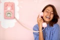 A beautiful young girl talking on a retro looking telephone hanging on the wall in a pastry shop. Pastry shop, ambience Royalty Free Stock Photo