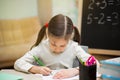 Beautiful young girl is teaching at home on blackboard. Preschool home education. Royalty Free Stock Photo