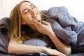 Beautiful young girl touches her face while lying in bed