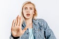 Beautiful young girl unhappy frown and says stop with a hand gesture on gray isolated background Royalty Free Stock Photo