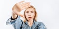 Beautiful young girl unhappy frown and says stop with a hand gesture on gray isolated background Royalty Free Stock Photo