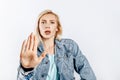 Beautiful young girl unhappy frown and says stop with a hand gesture on gray isolated background Royalty Free Stock Photo