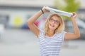 Beautiful young girl uses laptop as umbrella in hot summer day Royalty Free Stock Photo