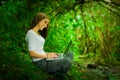 Beautiful young girl using laptop outdoors in the Royalty Free Stock Photo