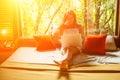 Beautiful young girl using a laptop in room on bed in jungle resort eco house Royalty Free Stock Photo