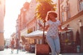 Beautiful young girl using smartphone and listening to the music walking on street. Woman dancing and singing Royalty Free Stock Photo