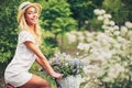 Beautiful young girl with vintage bicycle and flowers on city ba Royalty Free Stock Photo