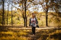 Beautiful young girl walking barefoot with sneakers in hand into the forest. There is a sunny autumn day with yellow leaves and dr Royalty Free Stock Photo