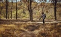 Beautiful young girl walking barefoot with sneakers in hand into the forest Royalty Free Stock Photo