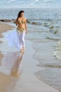 Beautiful young girl walking on beach Royalty Free Stock Photo