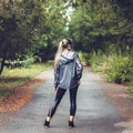 Beautiful young girl walking on park, listening to music on hea Royalty Free Stock Photo