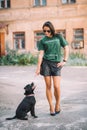 Beautiful young girl walking her pet dog Staffordshire bull terrier outdoors on a sunny day in summer. Quarantine. Animal training Royalty Free Stock Photo