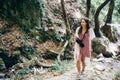 Beautiful, young girl walks at the foot of the mountain along