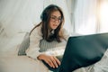 Beautiful young girl wearing glasses and headphones searching Internet Data Information with blank search bar with laptop on the Royalty Free Stock Photo