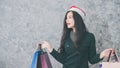 Beautiful young girl wearing a Santa hat holding lots of shopping bags Royalty Free Stock Photo