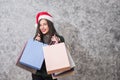 Beautiful young girl wearing a Santa hat holding lots of shopping bags Royalty Free Stock Photo