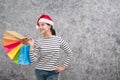 Beautiful young girl wearing a Santa hat holding lots of shopping bags Royalty Free Stock Photo