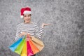 Beautiful young girl wearing a Santa hat holding lots of shopping bags Royalty Free Stock Photo