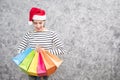 Beautiful young girl wearing a Santa hat holding lots of shopping bags Royalty Free Stock Photo