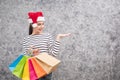 Beautiful young girl wearing a Santa hat holding lots of shopping bags Royalty Free Stock Photo