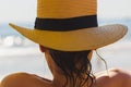 Beautiful young girl wearing a yellow straw hat at the beach Royalty Free Stock Photo