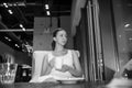 Beautiful young girl in white dress with white cup of coffee is sitting in the urban vintage cafe and tenderness looking afar Royalty Free Stock Photo