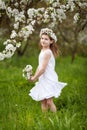 Beautiful young girl in white dress in the garden with blosoming  apple trees. Smiling girl  having fun and enjoying Royalty Free Stock Photo