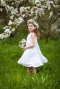 Beautiful young girl in white dress in the garden with blosoming  apple trees. Smiling girl  having fun and enjoying Royalty Free Stock Photo