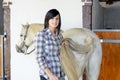 Beautiful young girl and white horse in the stable Royalty Free Stock Photo