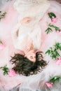 Beautiful young girl in a white lace dress with peony flowers Royalty Free Stock Photo