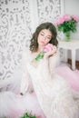 Beautiful young girl in a white lace dress with peony flowers Royalty Free Stock Photo