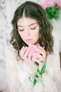 Beautiful young girl in a white lace dress with peony flowers Royalty Free Stock Photo