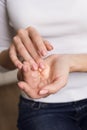 Beautiful young girl in white longsleeve moisturizes her hands with cream. Nails Applying Cosmetic Hand Cream On Soft Silky