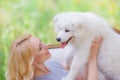 Beautiful young girl with a white puppy in her arms on a retro sofa in a summer garden Royalty Free Stock Photo