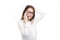 Beautiful young girl in a white shirt on white isolated background talking on a mobile phone. Smiles portrait to the waist Royalty Free Stock Photo