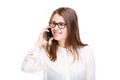 Beautiful young girl in a white shirt on white isolated background talking on a mobile phone. Smiles portrait to the waist Royalty Free Stock Photo