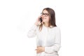 Beautiful young girl in a white shirt on white isolated background talking on a mobile phone. Smiles portrait to the waist Royalty Free Stock Photo