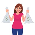 Beautiful young girl, woman or female holding/showing money, cash or currency notes bags with dollar sign. Successful business. Royalty Free Stock Photo