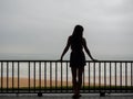 Beautiful young girl or woman standing on a balcony or terrace overlooking the sea Royalty Free Stock Photo